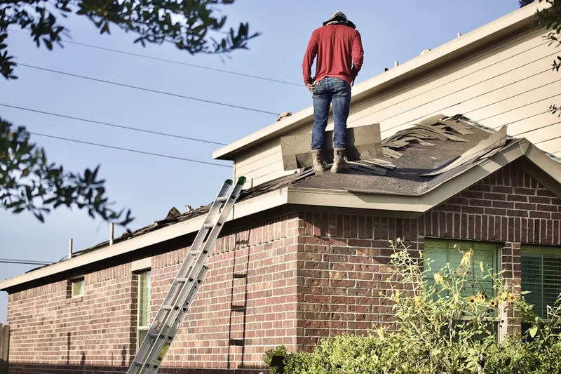 Professional roofer working on a residential roof in Flushing